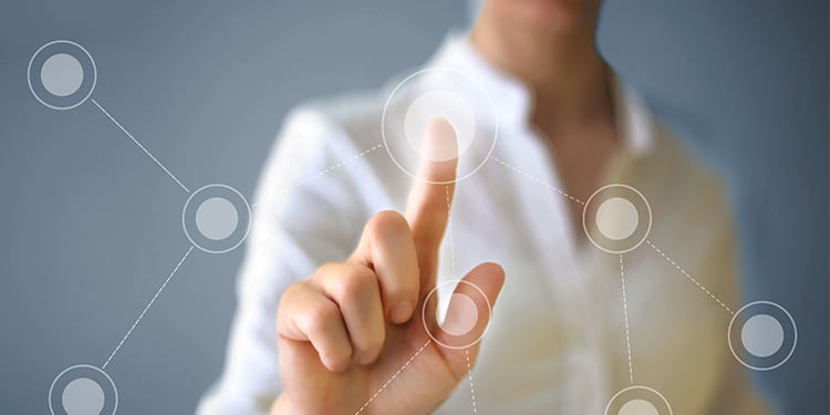 A stock photo of a woman pressing a floating dot with her finger.