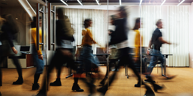 A photo of people walking in an office space.